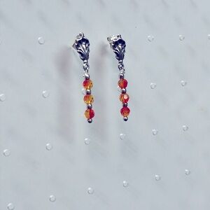 Sterling silver post earrings with flame orange bead dangle.
